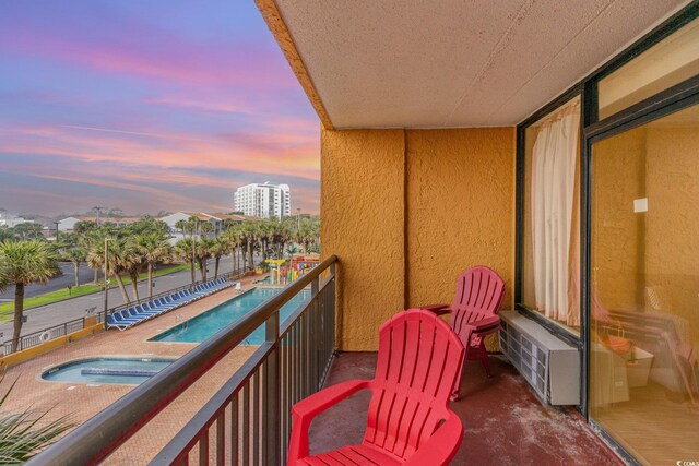 balcony at dusk featuring radiator heating unit