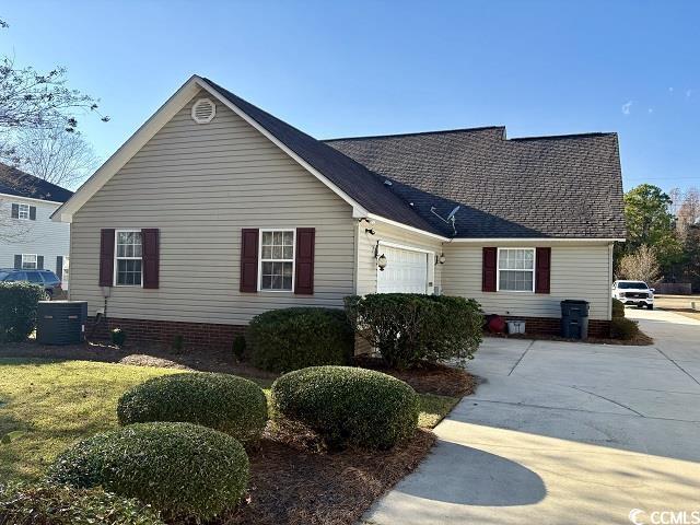 single story home with a garage and cooling unit