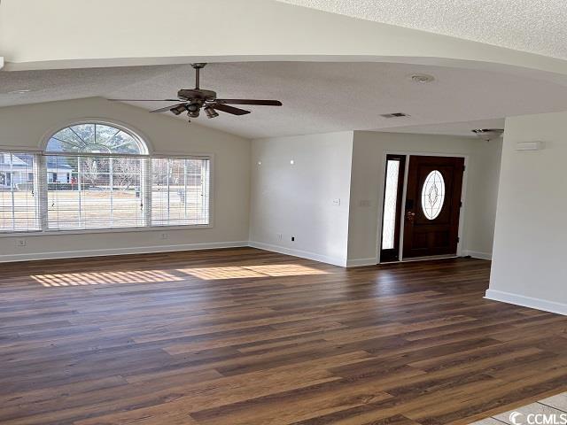 entrance foyer with a textured ceiling, dark wood-type flooring, lofted ceiling, and ceiling fan