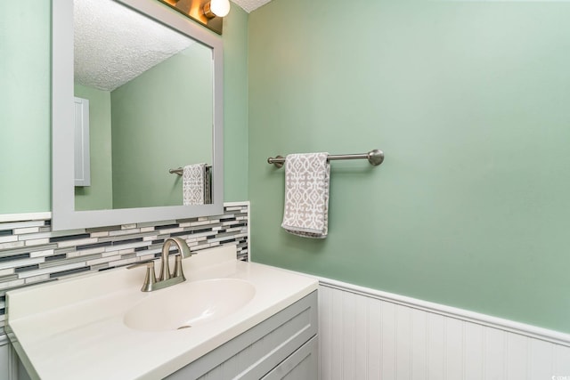 775 Plantation Dr Unit 59, Little River, SC 29566 - bathroom featuring vanity, tasteful backsplash, a textured ceiling, and wainscoting