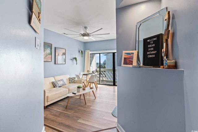 living room with ceiling fan and light hardwood / wood-style flooring