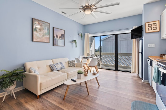 living room featuring hardwood / wood-style floors and ceiling fan