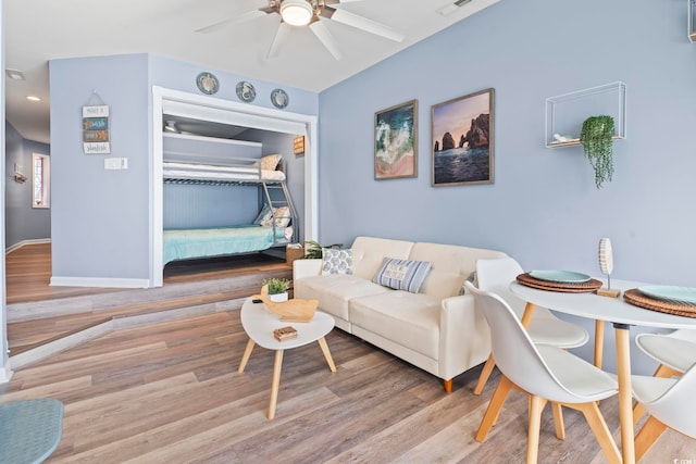 living room with light wood-type flooring and ceiling fan