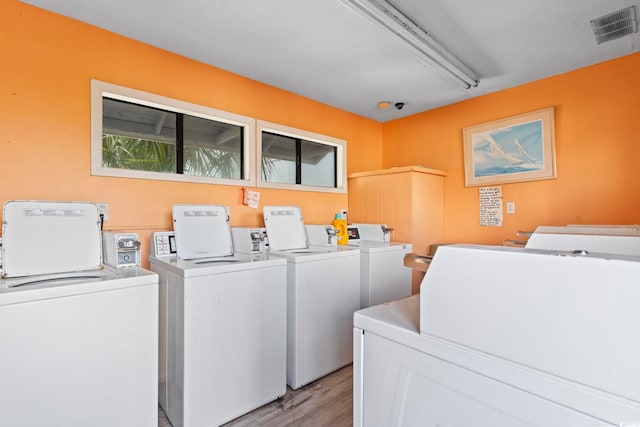 laundry area with washing machine and dryer and light wood-type flooring