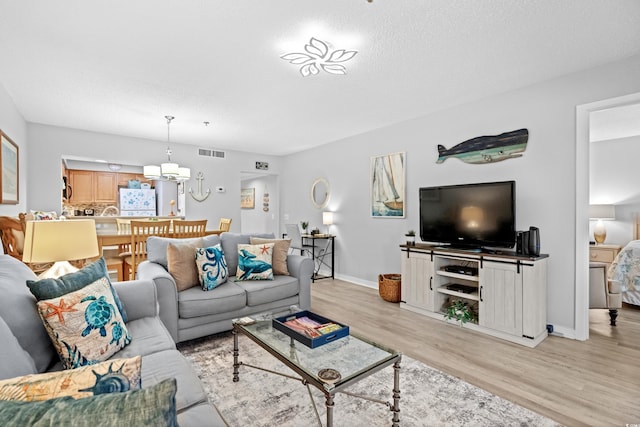 living room featuring light hardwood / wood-style floors and a textured ceiling