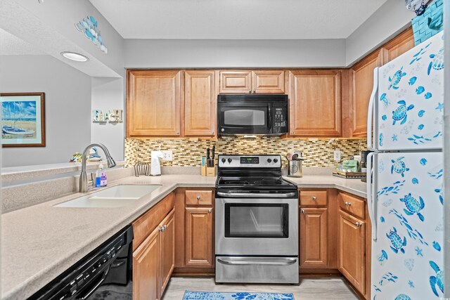 kitchen with black appliances, light wood-type flooring, sink, and tasteful backsplash