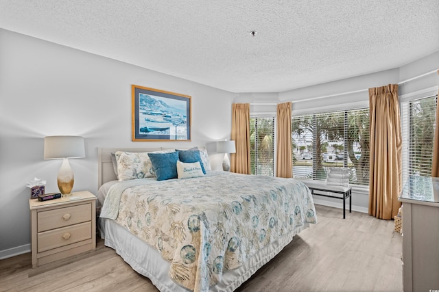 bedroom featuring light hardwood / wood-style floors and a textured ceiling