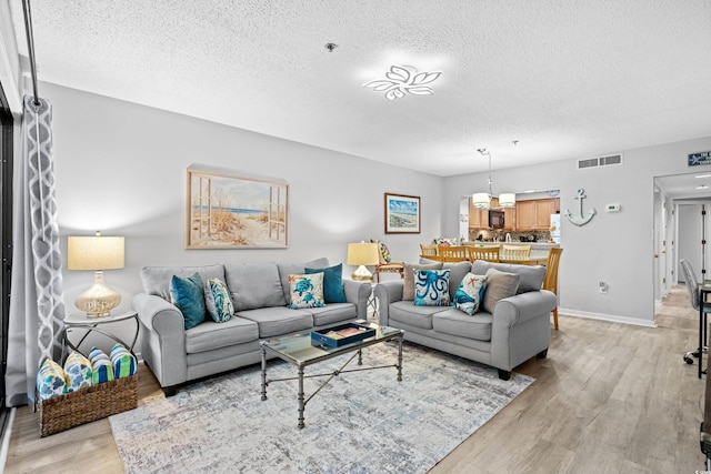 living room featuring light hardwood / wood-style floors and a textured ceiling