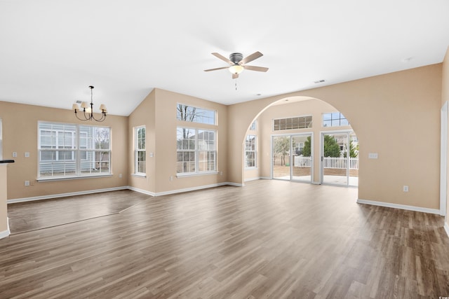 unfurnished living room with wood-type flooring and ceiling fan with notable chandelier