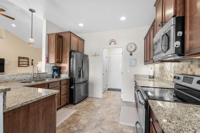 kitchen featuring sink, stainless steel appliances, light stone counters, backsplash, and decorative light fixtures