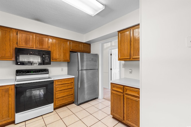 kitchen featuring white range with electric stovetop, stainless steel fridge, light tile patterned floors, and a textured ceiling