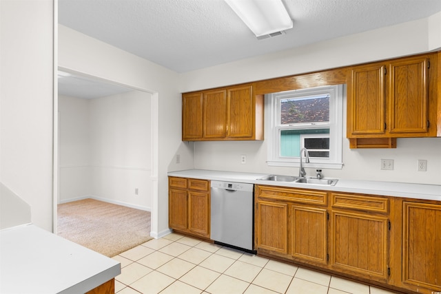 kitchen featuring dishwasher, light tile patterned floors, a textured ceiling, and sink