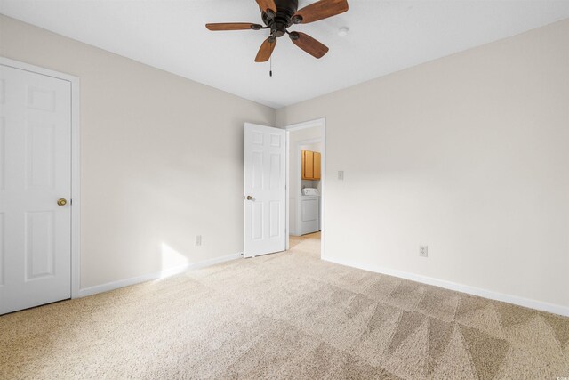 spare room with light carpet, washer / clothes dryer, and ceiling fan