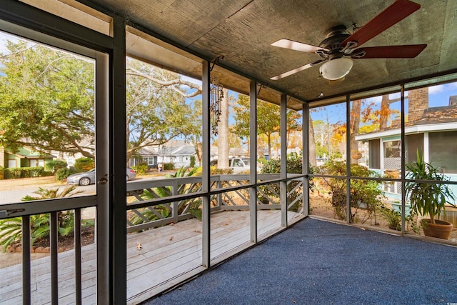 unfurnished sunroom with ceiling fan