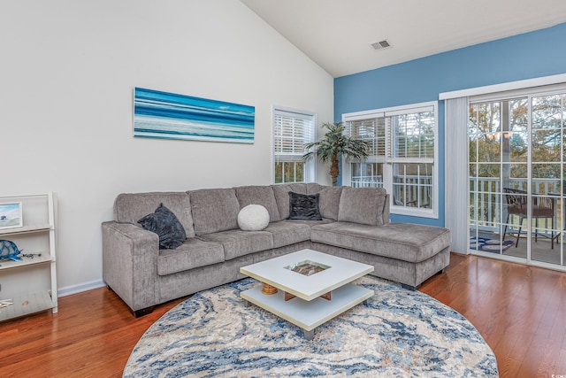 living room with hardwood / wood-style floors and high vaulted ceiling