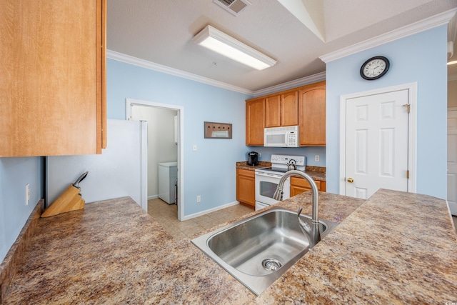 kitchen featuring ornamental molding, white appliances, sink, washer / clothes dryer, and light tile patterned flooring