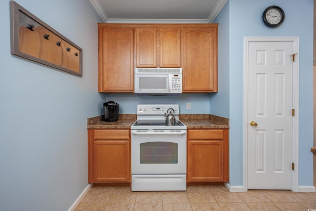 kitchen with light tile patterned flooring, white appliances, and ornamental molding