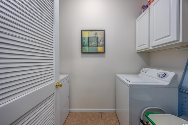 washroom with washing machine and clothes dryer, light tile patterned flooring, and cabinets