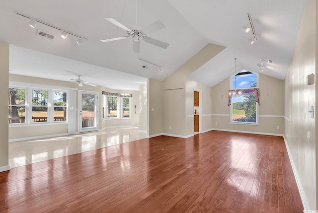 unfurnished living room with rail lighting, hardwood / wood-style flooring, ceiling fan, and lofted ceiling