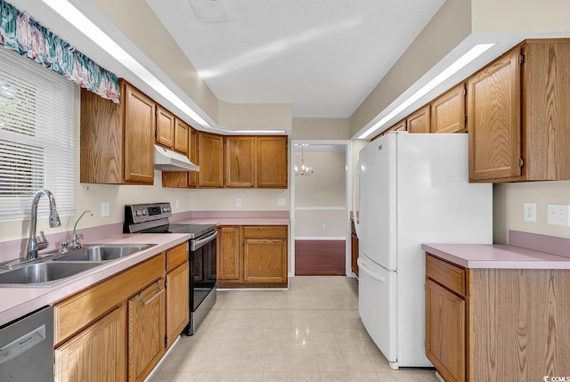 kitchen with light tile patterned floors, stainless steel appliances, an inviting chandelier, and sink