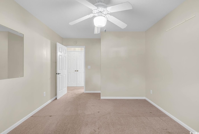 empty room with ceiling fan and light colored carpet