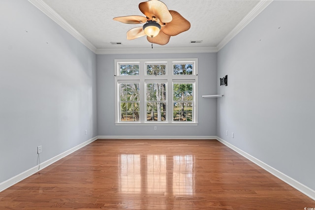 spare room featuring ceiling fan, wood-type flooring, a textured ceiling, and ornamental molding