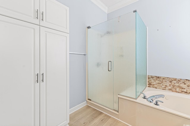 bathroom with ornamental molding, shower with separate bathtub, and hardwood / wood-style flooring