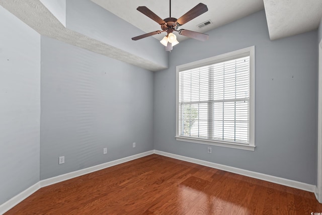 empty room with ceiling fan, vaulted ceiling, and hardwood / wood-style floors