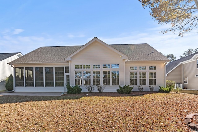 back of house featuring a sunroom and a lawn