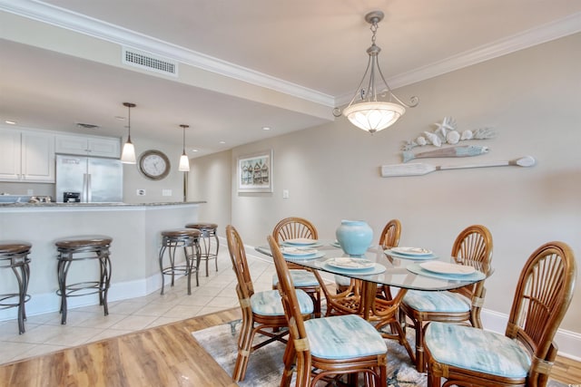 603 S Ocean Blvd Unit 1002, North Myrtle Beach, SC 29582 - dining area featuring light wood-style floors, ornamental molding, and baseboards