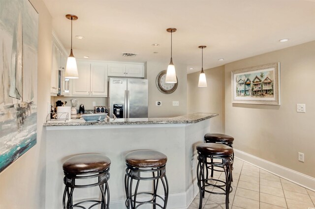 603 S Ocean Blvd Unit 1002, North Myrtle Beach, SC 29582 - kitchen with stainless steel refrigerator with ice dispenser, a peninsula, a breakfast bar, white cabinets, and light tile patterned floors