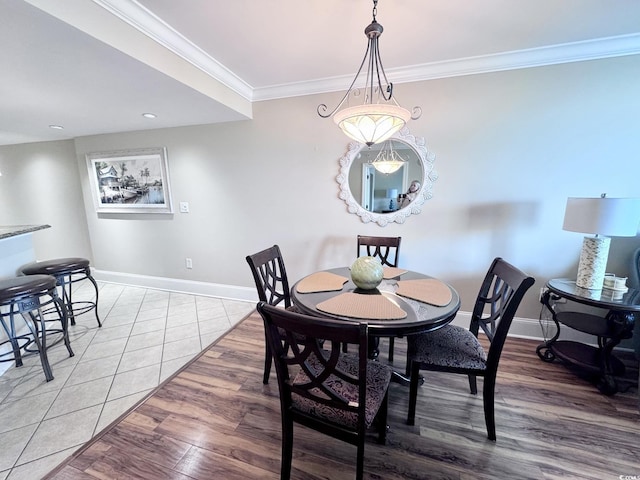 dining space with hardwood / wood-style flooring and ornamental molding