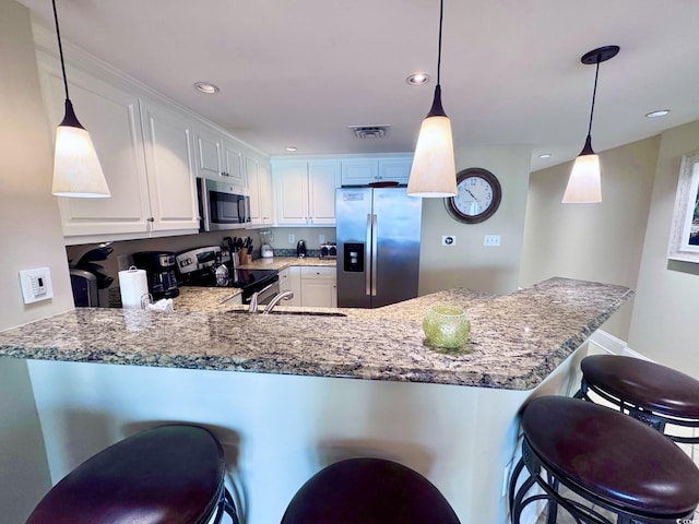 kitchen with kitchen peninsula, white cabinetry, hanging light fixtures, and stainless steel appliances