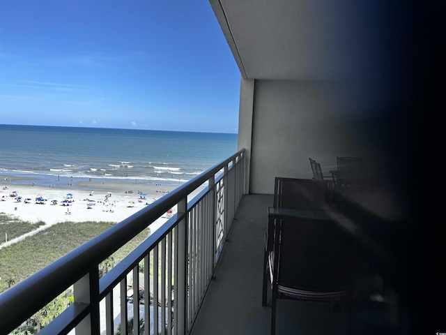 balcony featuring a beach view and a water view