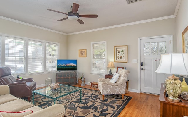 living room with ceiling fan, light hardwood / wood-style flooring, a textured ceiling, and ornamental molding