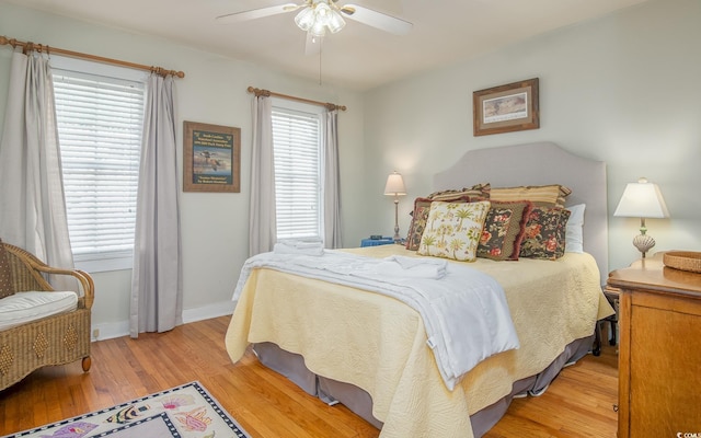 bedroom with multiple windows, ceiling fan, and light hardwood / wood-style flooring