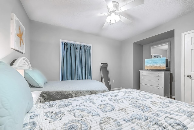 bedroom with ceiling fan and a textured ceiling