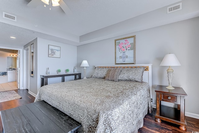 bedroom featuring connected bathroom, ceiling fan, and dark wood-type flooring