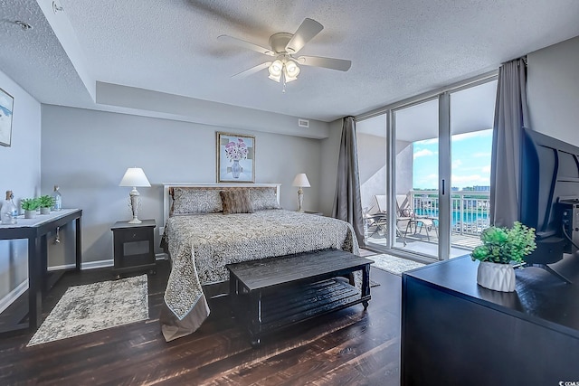 bedroom with access to exterior, dark hardwood / wood-style flooring, floor to ceiling windows, a textured ceiling, and ceiling fan