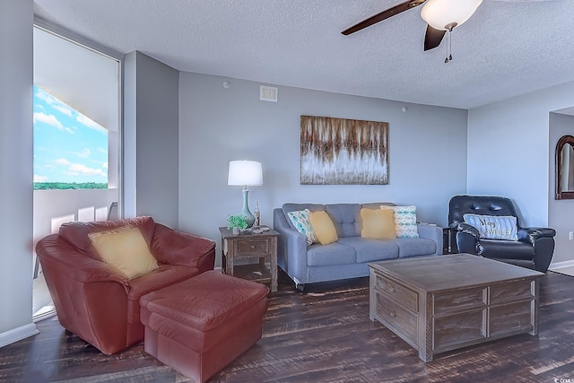 living room featuring ceiling fan, dark hardwood / wood-style flooring, and a textured ceiling