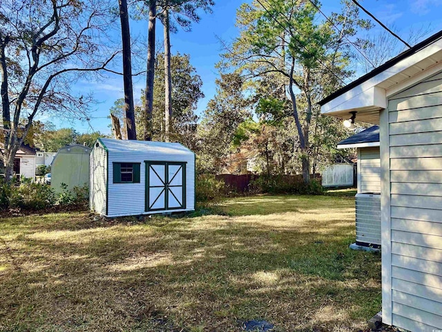 view of yard featuring a shed and central air condition unit