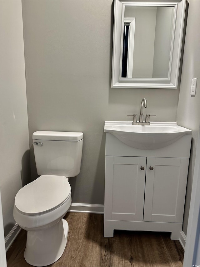 bathroom with hardwood / wood-style floors, vanity, and toilet