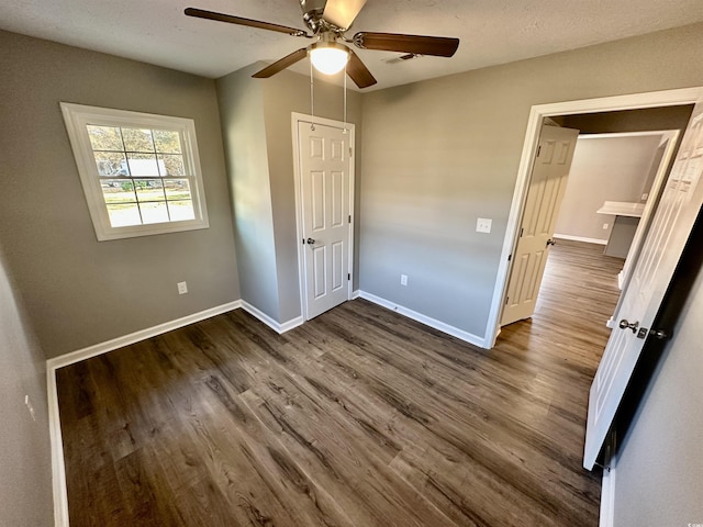 unfurnished bedroom with dark hardwood / wood-style floors and ceiling fan