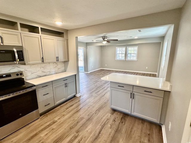 kitchen with decorative backsplash, appliances with stainless steel finishes, ceiling fan, and a healthy amount of sunlight