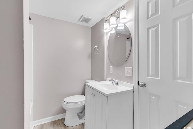 bathroom with hardwood / wood-style floors, vanity, and toilet