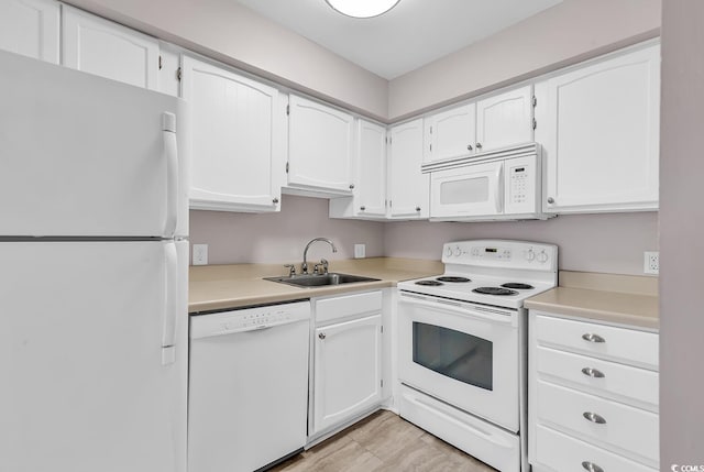 kitchen featuring sink, white cabinets, and white appliances