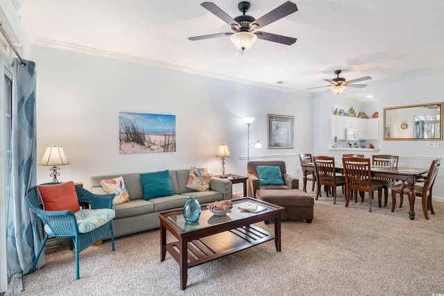 carpeted living room with ceiling fan and ornamental molding