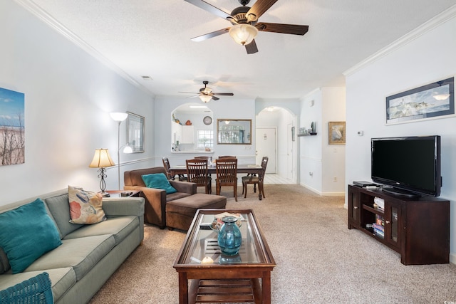 carpeted living room featuring a textured ceiling, ceiling fan, and ornamental molding