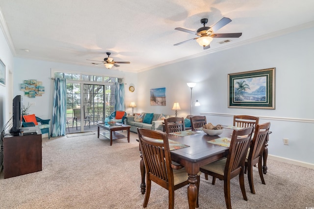 dining area with ceiling fan, light colored carpet, and ornamental molding