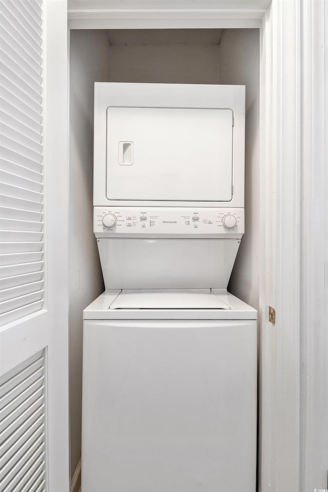 washroom featuring stacked washer and clothes dryer